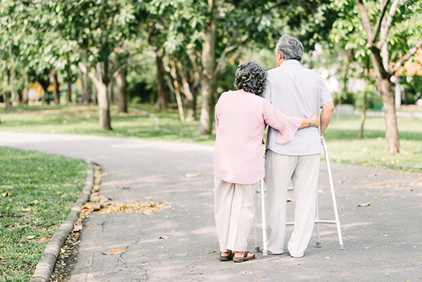 Senior couple talking a walk with walker