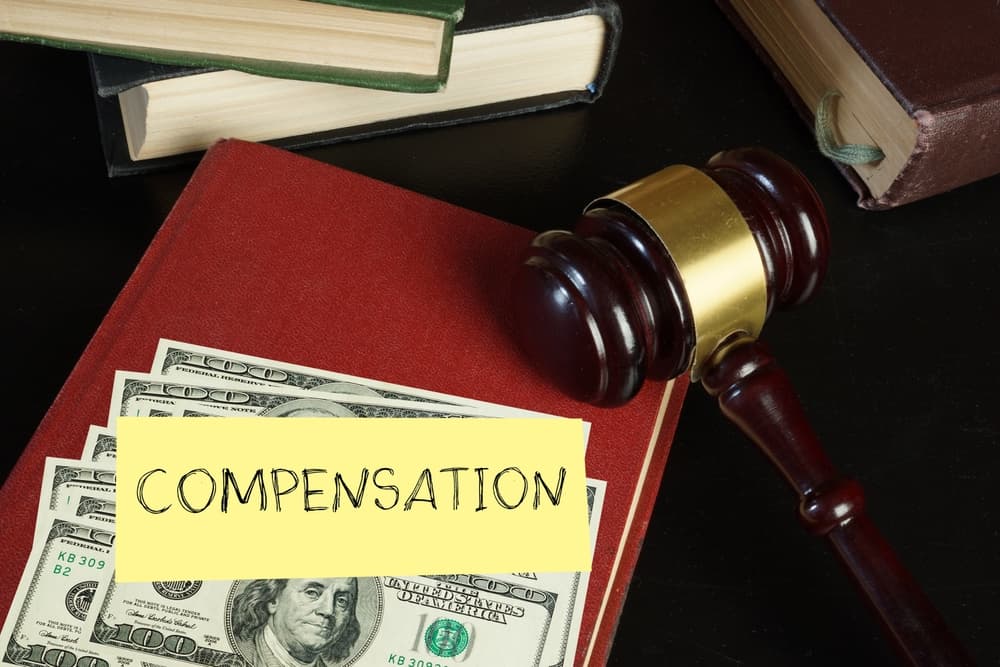 Money, legal books, and a judge&rsquo;s gavel representing compensation available in a wrongful death claim after a fatal car accident.