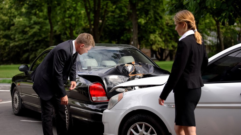 Insurance adjuster inspecting vehicle damage after an accident